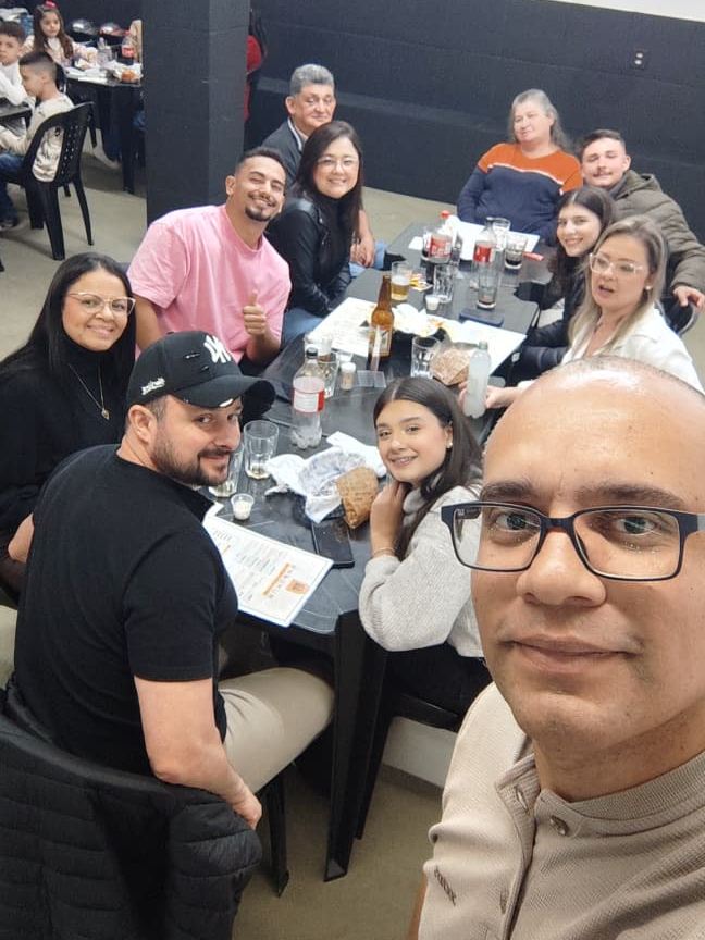 Família reunida em uma confraternização na DIO, tirando selfie à mesa